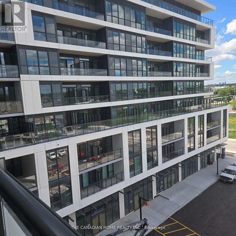 A modern multi-story building with a glass facade and balconies.
