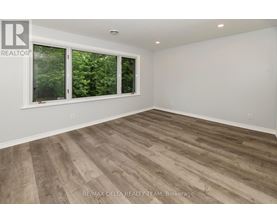 A room with a window and wooden flooring.