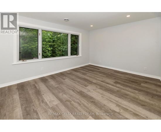 A room with a window and wooden flooring.