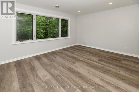 A room with a window and wooden flooring.