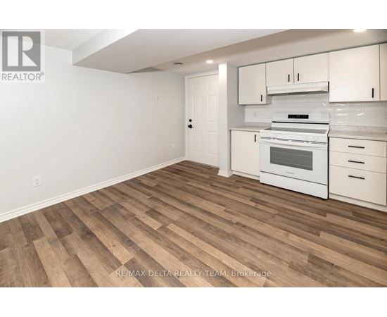 A kitchen with white cabinets and a stove top oven.