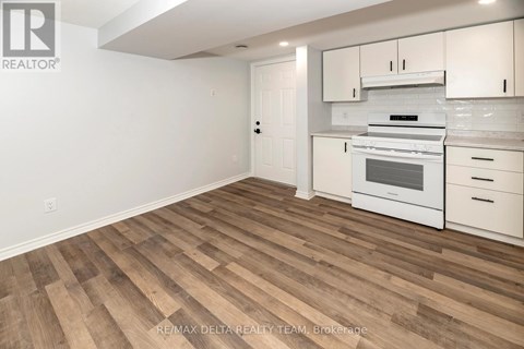 A kitchen with white cabinets and a stove top oven.