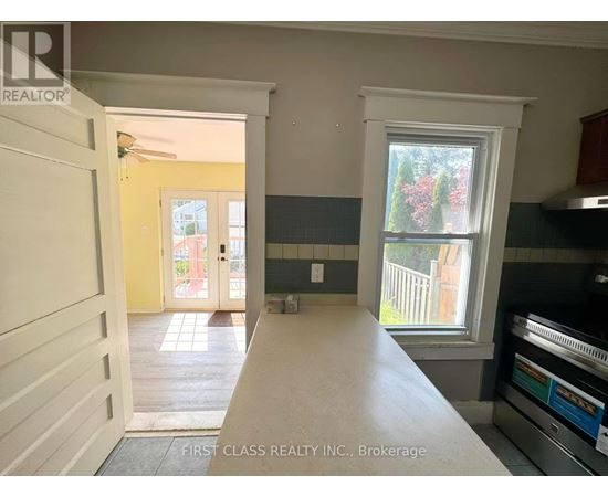 A kitchen with a stove top oven and a window.