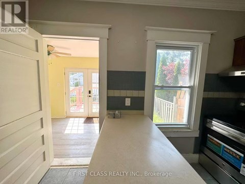 A kitchen with a stove top oven and a window.