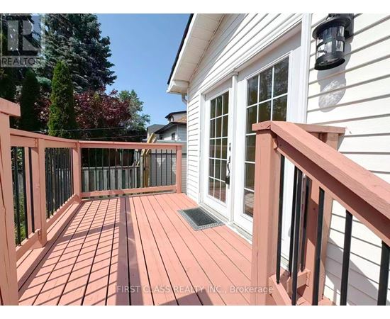 A wooden deck with a black railing and a window.