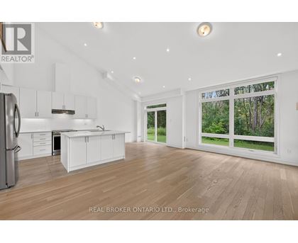 A spacious kitchen with white cabinets and a refrigerator.