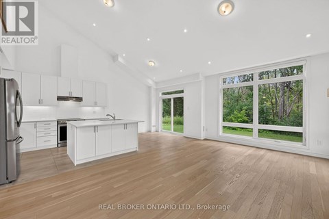 A spacious kitchen with white cabinets and a refrigerator.