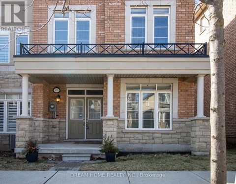 A brick house with a balcony and a front door.