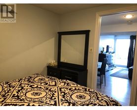 A bedroom with a black and white patterned bedspread.