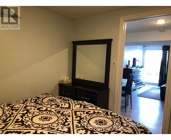 A bedroom with a black and white patterned bedspread.
