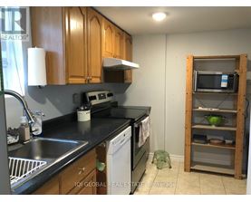 A kitchen with wooden cabinets and a black countertop.