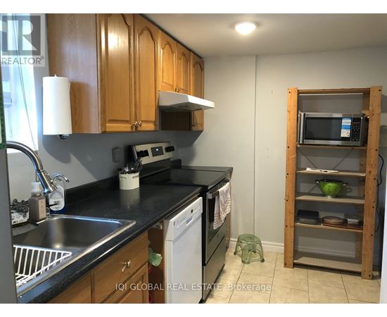 A kitchen with wooden cabinets and a black countertop.