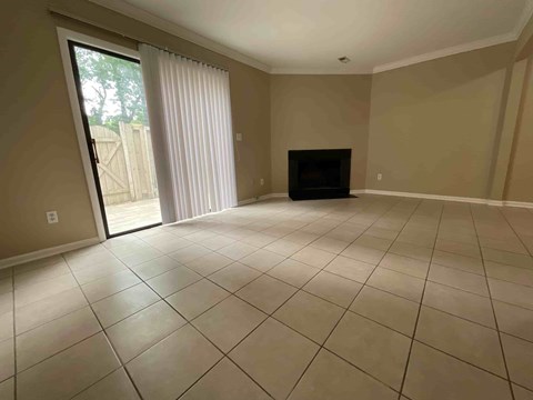 A living room with a fireplace and sliding glass doors.