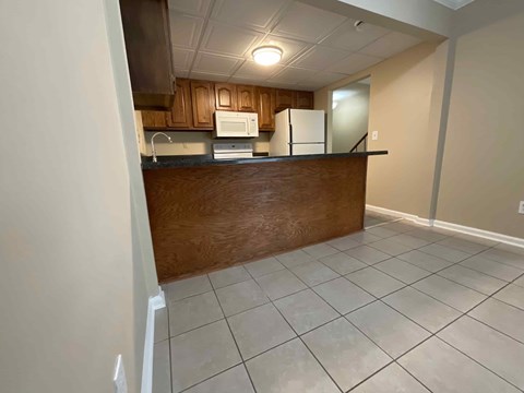 A kitchen with a white fridge and microwave above a counter.
