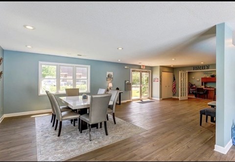 A dining room with a table and chairs.