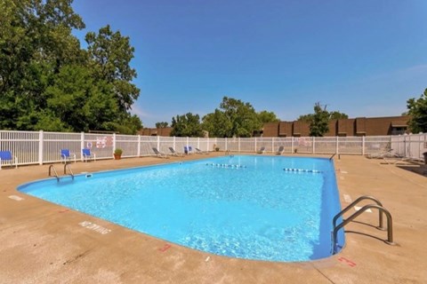 A large blue swimming pool surrounded by a white fence.
