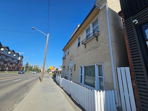 A street view with a building on the right and a clear blue sky.