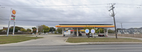 A gas station with a sign that has a red circle with a white line through it.
