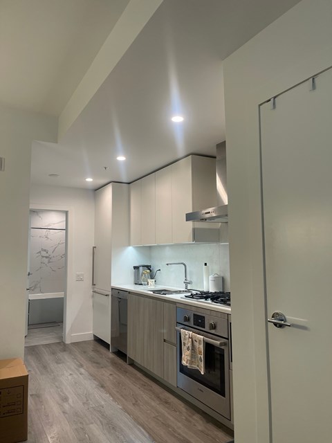 A modern kitchen with a stove top oven and a refrigerator.