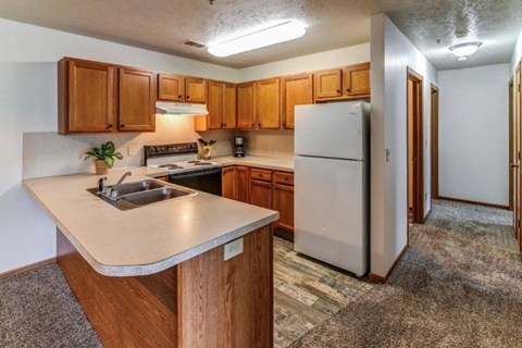 A kitchen with wooden cabinets and a white refrigerator.