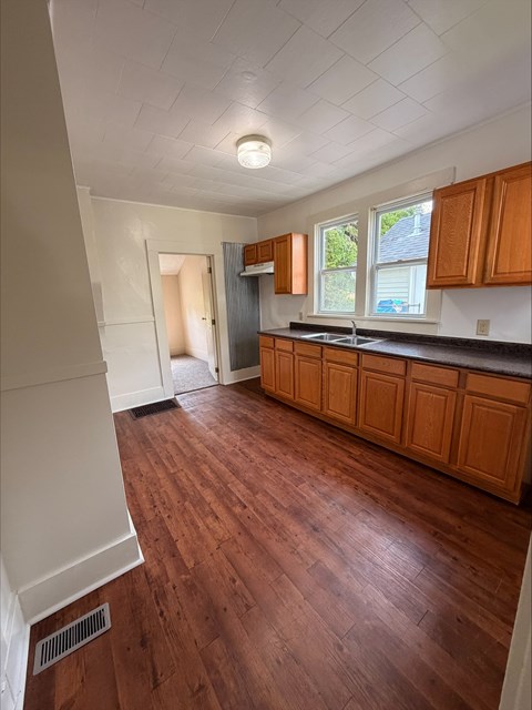 A kitchen with wooden floors and white walls.