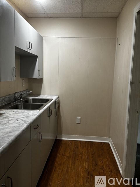 A kitchen with white cabinets and a marble countertop.