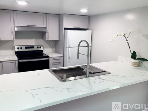 A modern kitchen with a stainless steel refrigerator and a marble countertop.