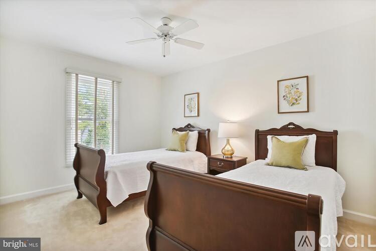 A bedroom with two beds and a ceiling fan.