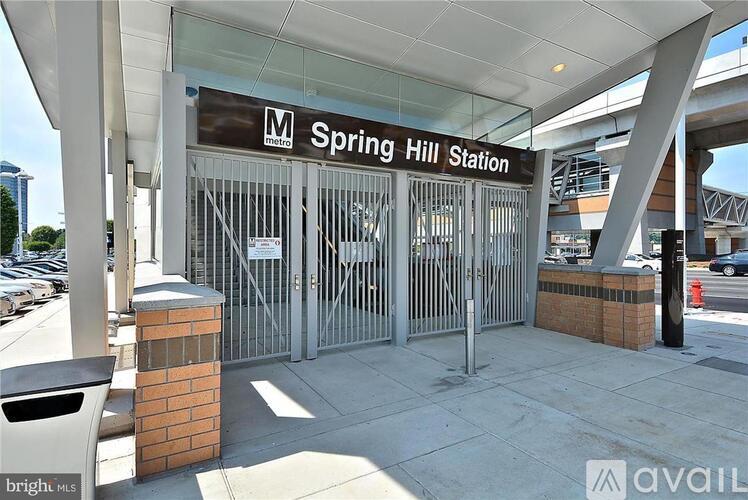 Spring Hill Station entrance with a sign and a trash can.