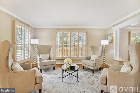 A living room with beige chairs and a coffee table.