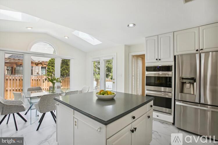 A kitchen with white cabinets and a black countertop.