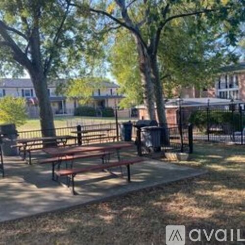 A park with picnic tables and trees.