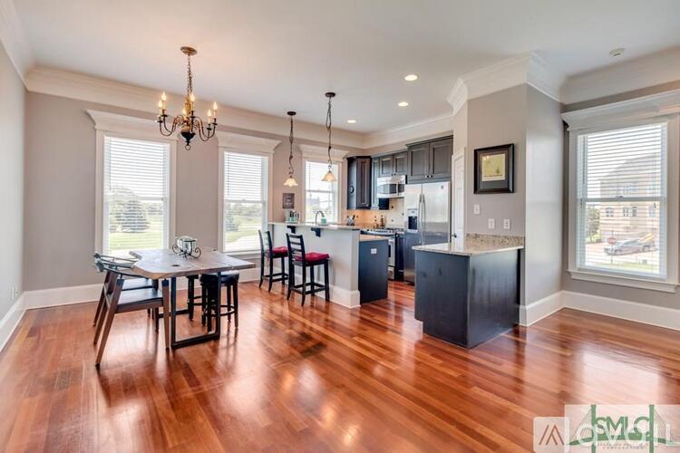 A well-lit kitchen with a dining table and chairs.