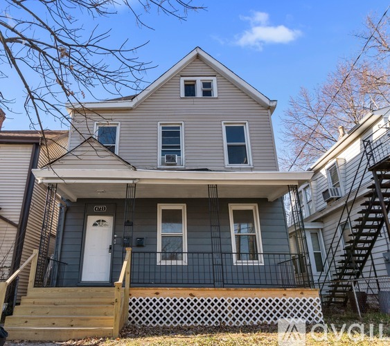 A two-story house with a front porch and a white door.