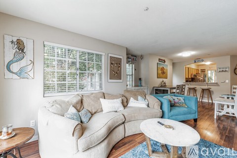 A living room with a white couch and a blue chair.