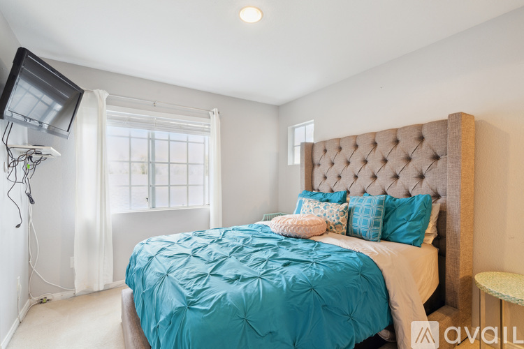 A bedroom with a large bed and a flat screen TV mounted on the wall.
