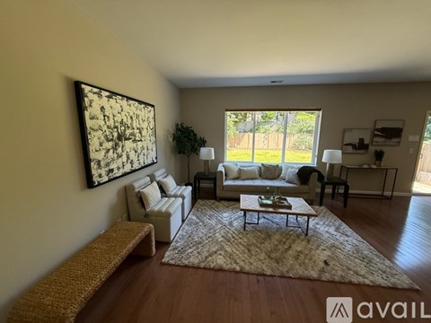 A living room with a couch, coffee table, and a large painting on the wall.