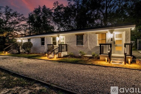 A house with a front porch is lit up at night.