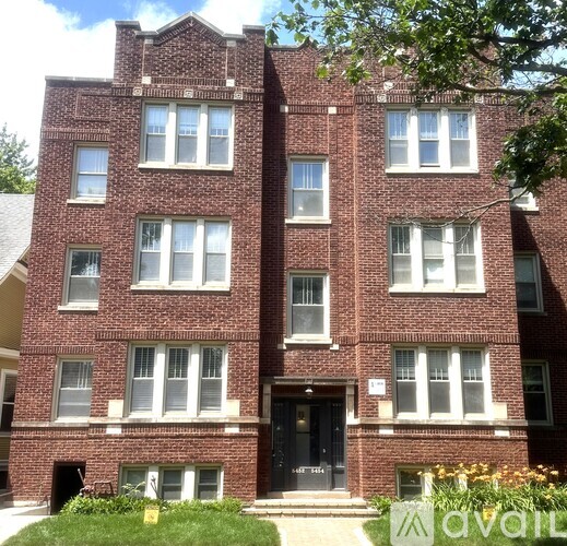 A red brick building with a black door and windows.