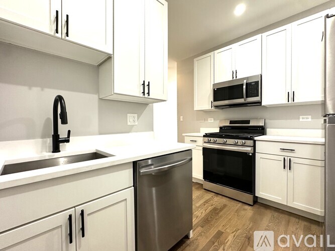 A kitchen with white cabinets and stainless steel appliances.