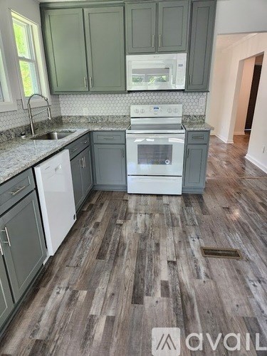 A kitchen with a white dishwasher and a white oven.