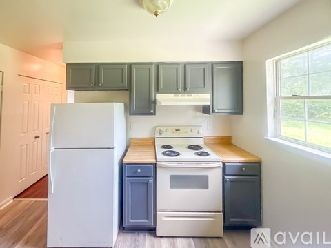 A kitchen with a white refrigerator, a white stove, and a white oven.