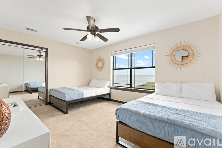 A bedroom with a large bed and a ceiling fan.