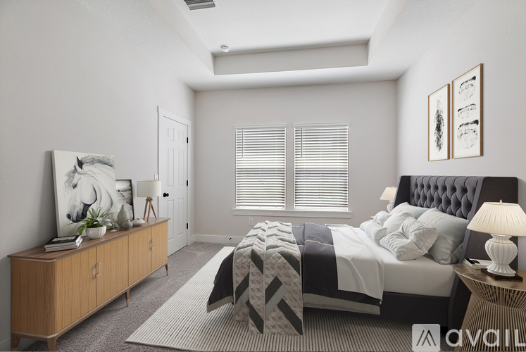 A bedroom with a bed, nightstand, and a cabinet with a painting on it.