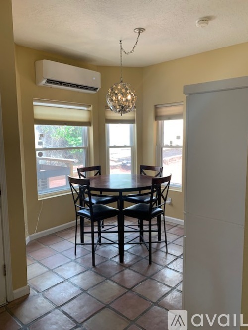 A dining room with a table and chairs.
