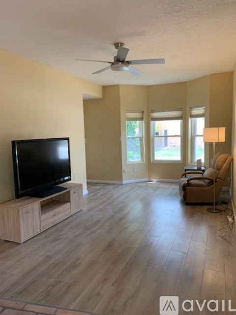A living room with a television and a chair.