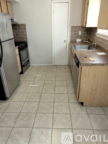 A kitchen with a white door and a sink.