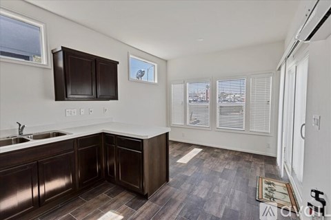 A kitchen with dark brown cabinets and a white sink.
