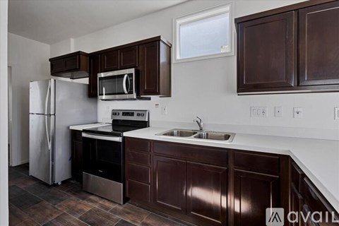 A kitchen with brown cabinets and a white fridge.