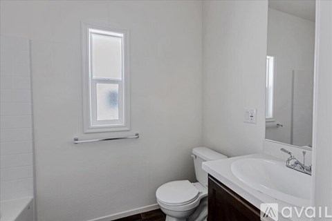 A white toilet sits next to a sink in a bathroom.